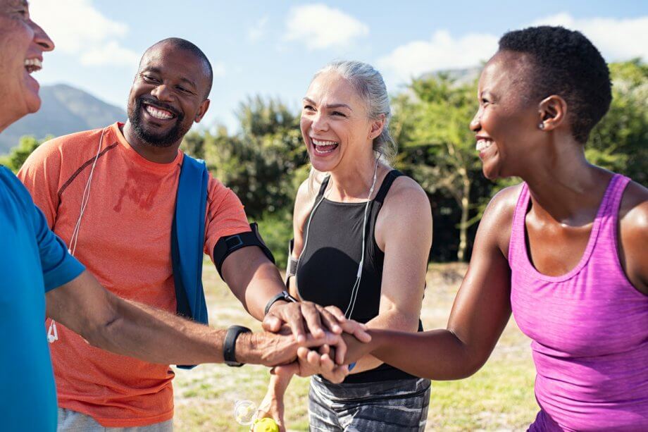 An older group of people outdoors and smiling.